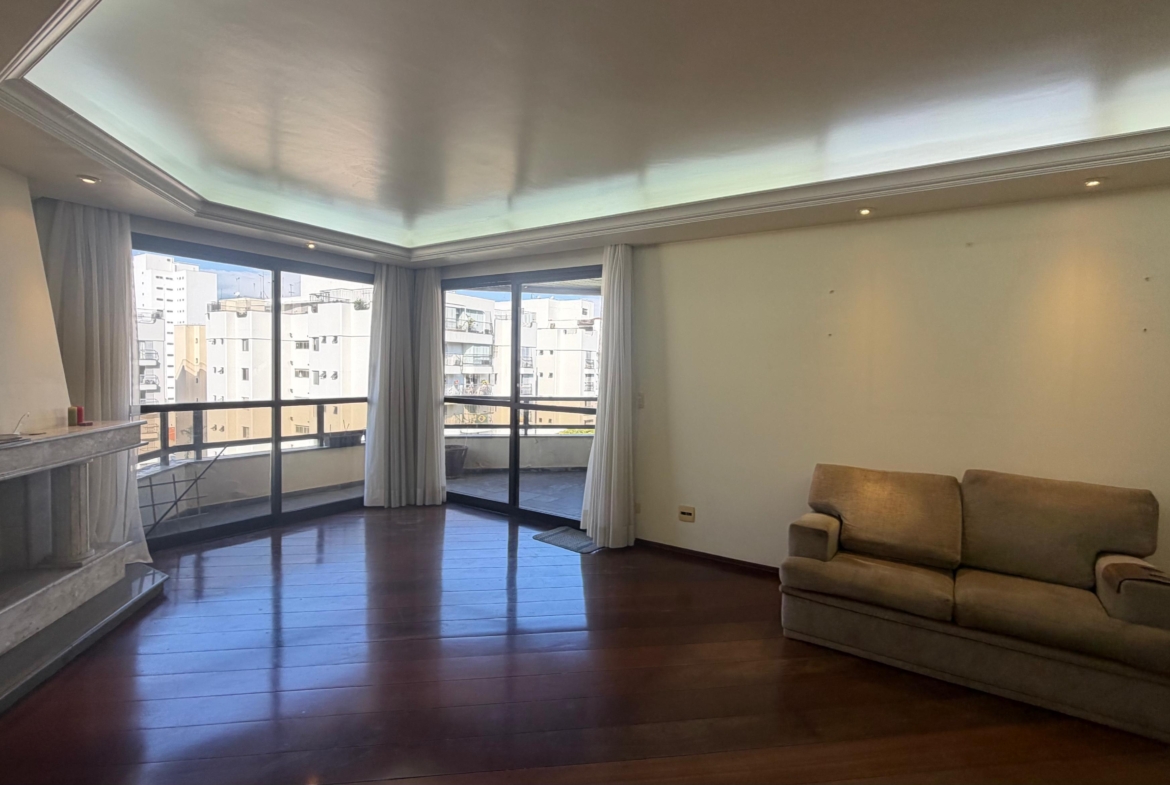 Sala ampla com lareira e piso de madeira no apartamento à venda na Lapa